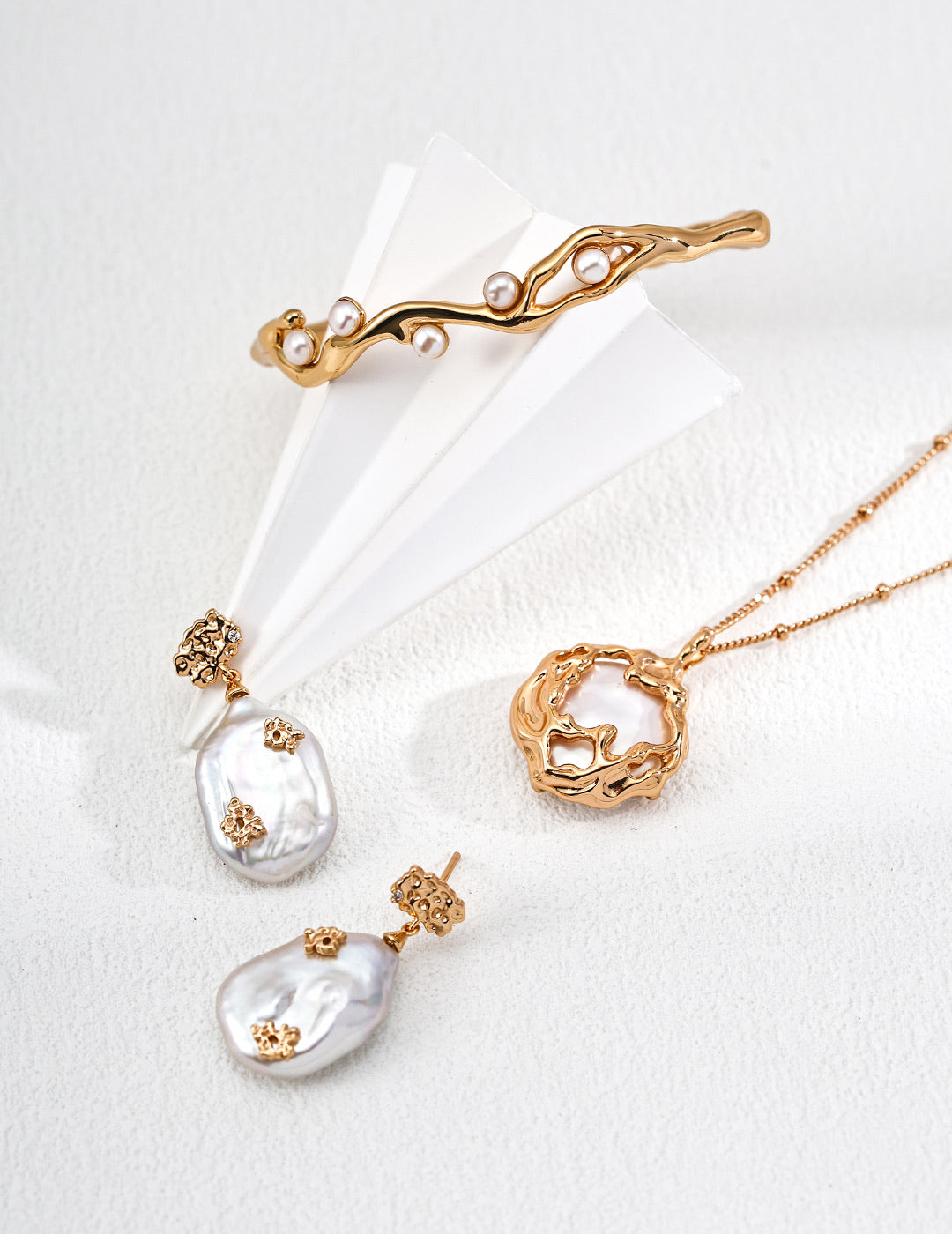 Mira Aura Necklaces and Pendants featuring organic gold pendant double chain baroque pearl drop earrings and branch cuff