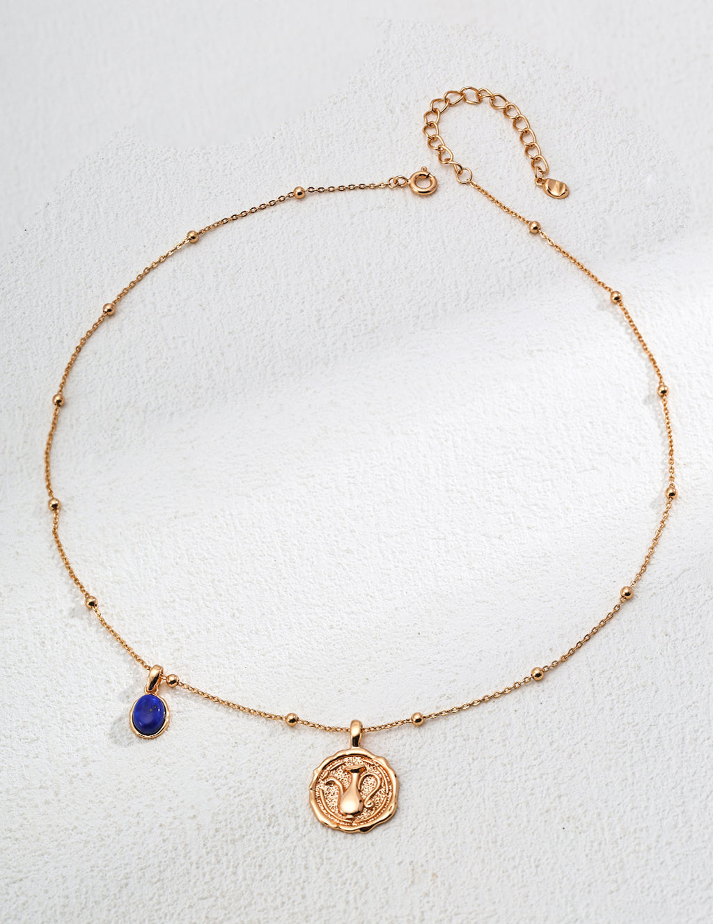 Mira Aura gold plated gemstone necklace with delicate beaded chain blue teardrop gemstone and coin pendant
