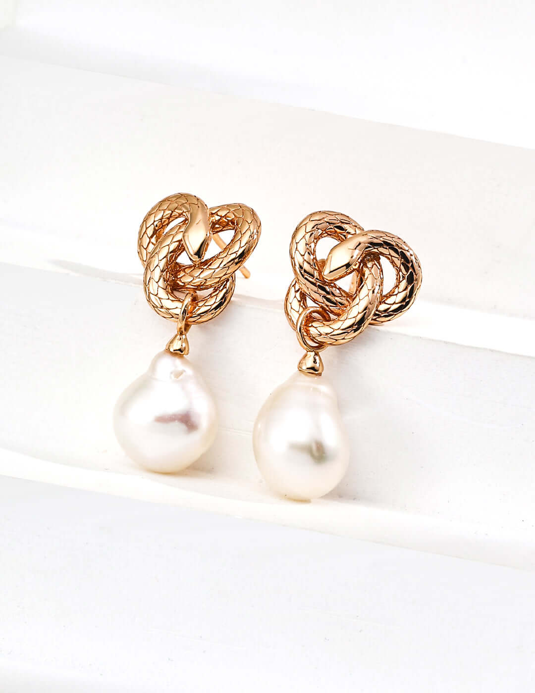 Mira Aura gold knot earrings with textured snake loops and dangling pearl drops unique snake motif jewelry