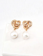 Mira Aura unique snake motif jewelry gold knot snake stud earrings with textured design and white pearl drop