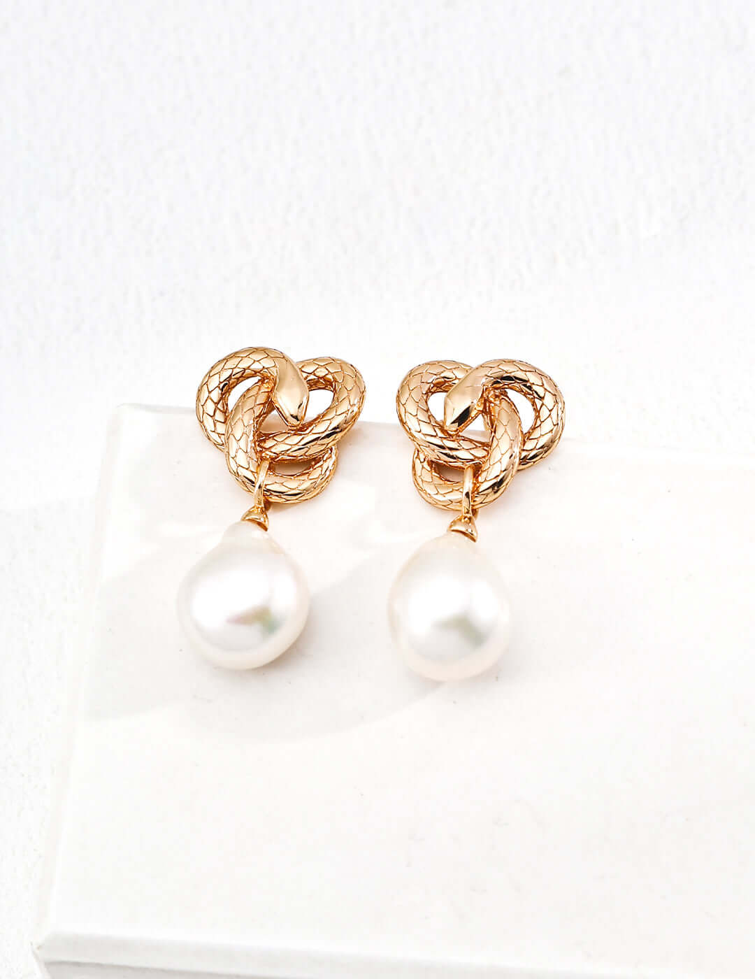 Mira Aura unique snake motif jewelry gold knot snake stud earrings with textured design and white pearl drop