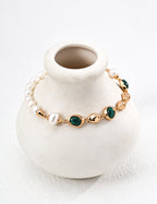 Mira Aura modern gemstone bracelet women with freshwater pearls gold links and green malachite stones on white vase