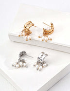 Gold and silver huggie hoop modern pearl earrings for women with dangling freshwater pearls on white display