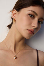 Mira Aura modern pearl earrings for women on model wearing gold pearl drop earrings with matching pendant necklace