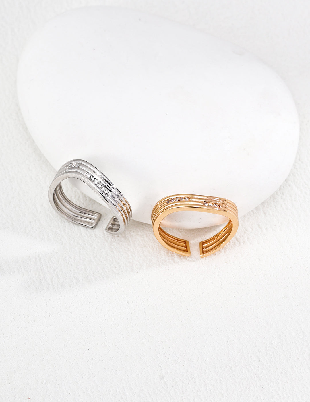 Gold plated adjustable ring for women in gold and silver tones displayed on a white stone background