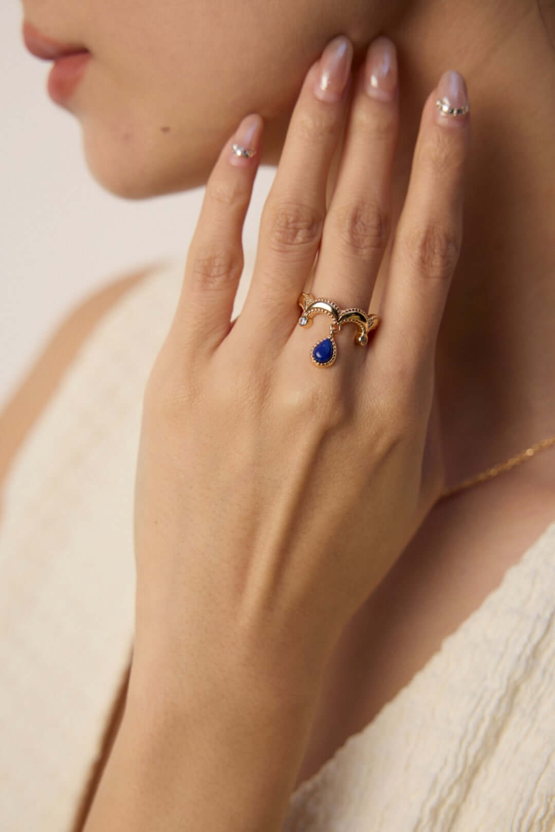 Mira Aura gold ring with blue teardrop gemstone worn on female hand showcasing a unique gemstone statement ring