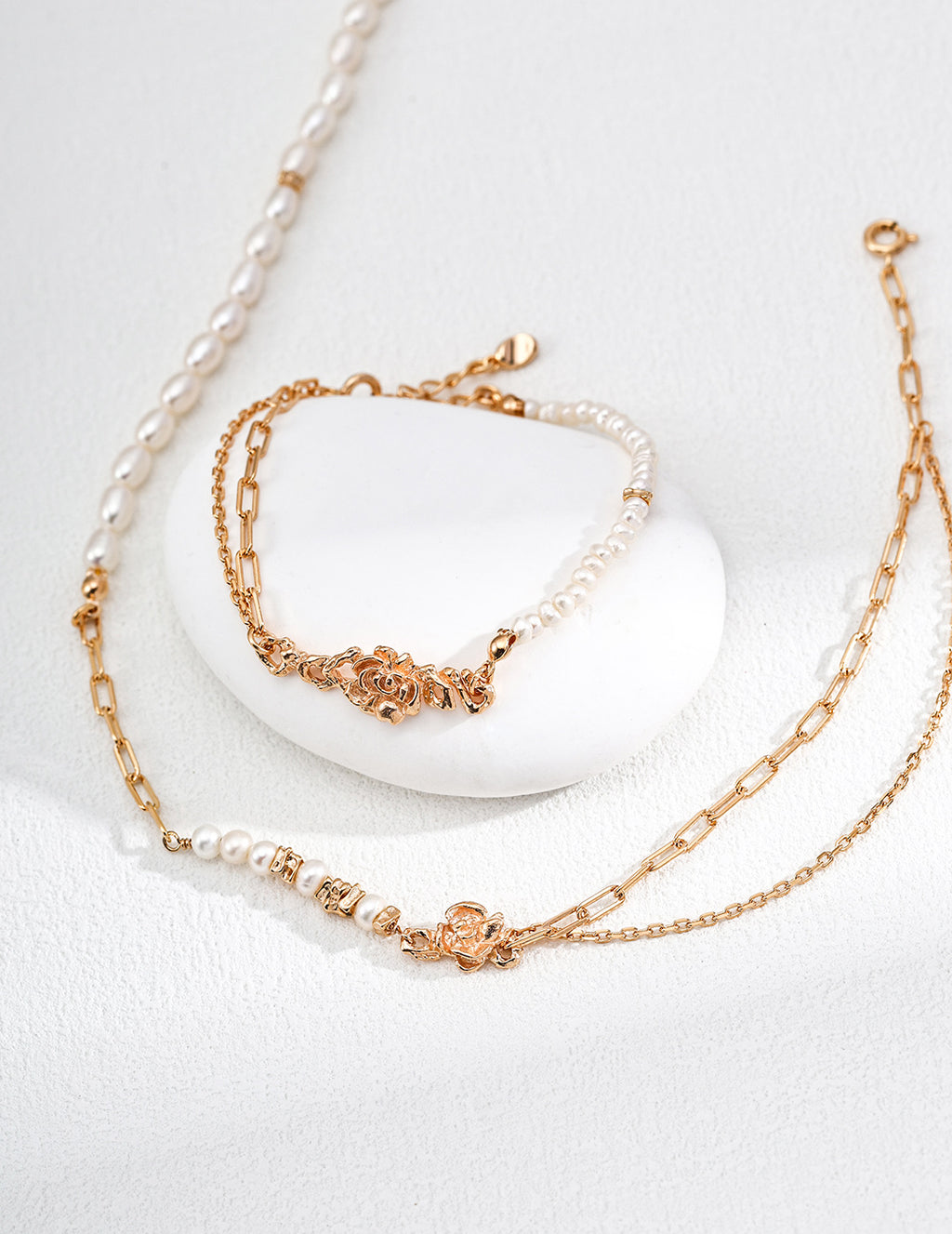 Mira Aura modern freshwater pearl bracelet set with gold chain links and ornate clasp on white textured background