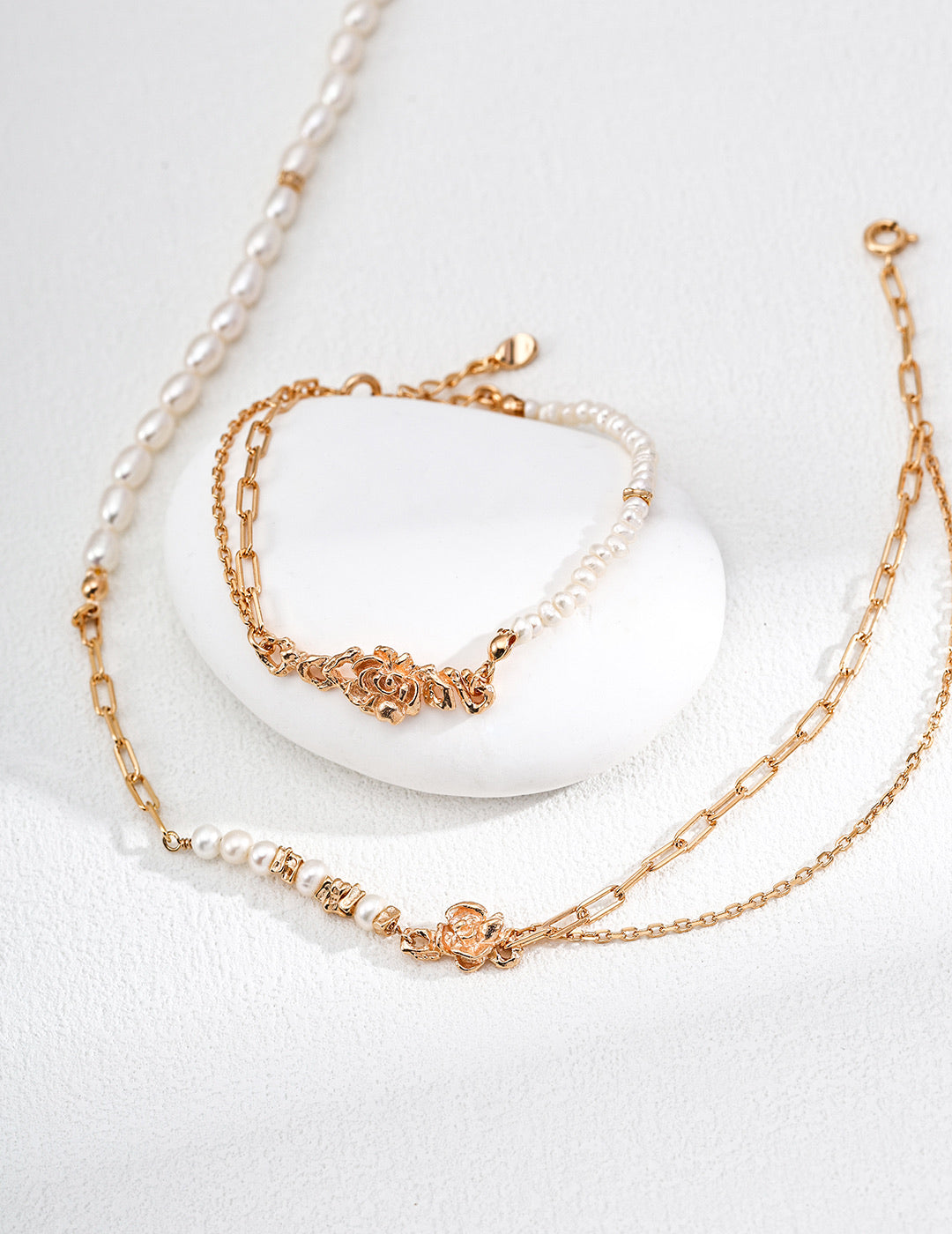 Mira Aura modern freshwater pearl bracelet set with gold chain links and ornate clasp on white textured background