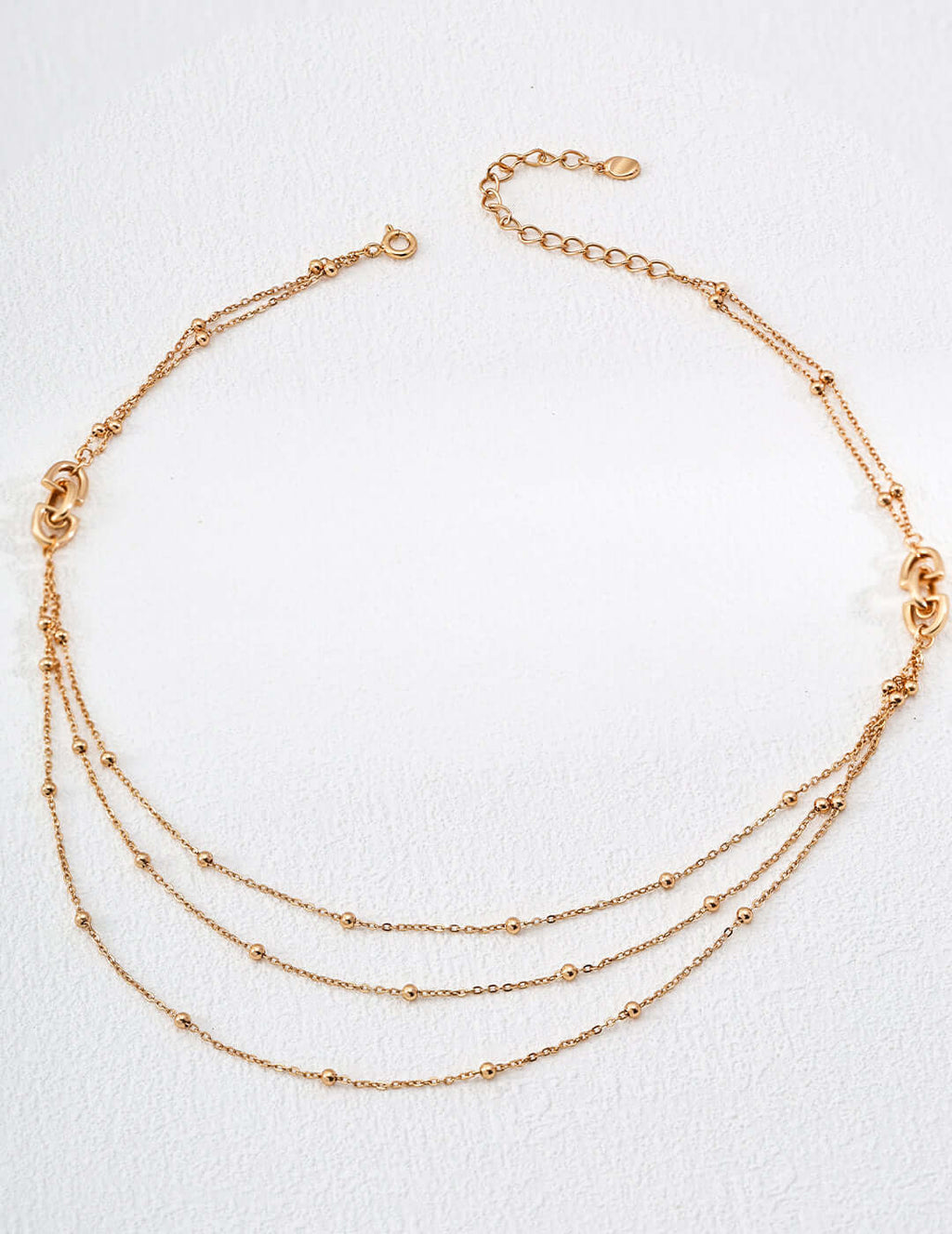 modern gold chain necklace Mira Aura triple layered delicate beaded chains with adjustable clasp on white