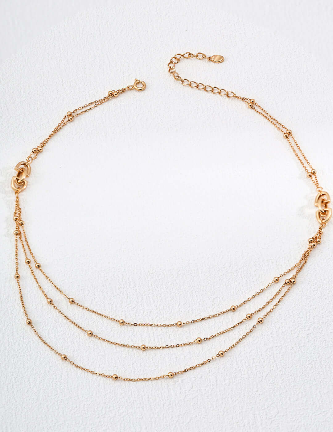 modern gold chain necklace Mira Aura triple layered delicate beaded chains with adjustable clasp on white