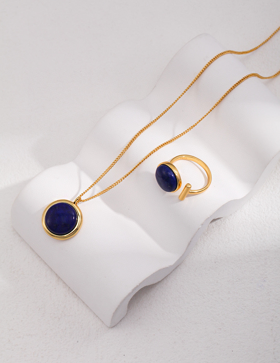 Modern gemstone bracelet women featuring gold ring and pendant with deep blue stone by Mira Aura